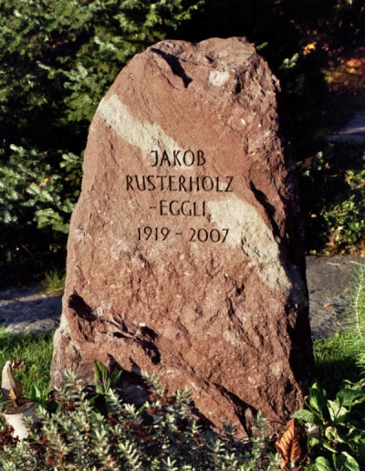 Naturbelassener Grabstein. Schlicht gehalten in rötlicher Farbe